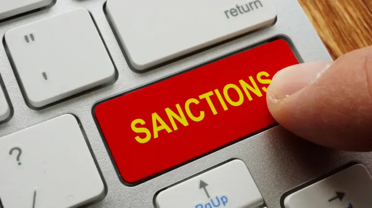 Будівля парламенту Великої Британії в Лондоні з прапором країни та переліком назв шести російських банків і шести санкційних
